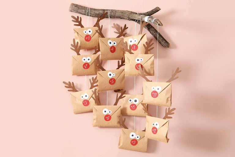 DIY Adventskalender mit Papierumschlägen, Geweih aus Papier und einem Ast als Aufhängung