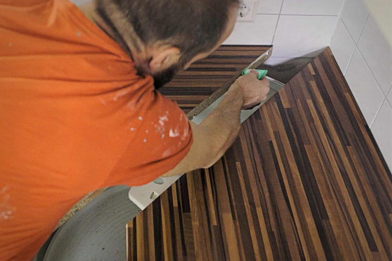 Handwerker verlegt eine Holz Arbeitsplatte in einer Küche