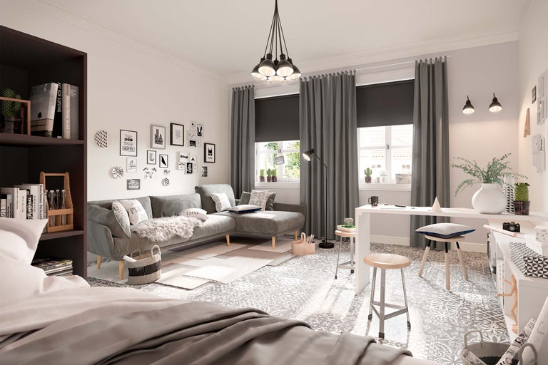 Wohnzimmer mit grauer Couch, Schreibtisch und dekorativen Elementen.