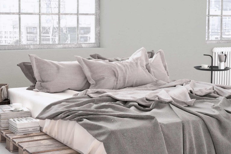 Schlafzimmer mit Bett, Kissen und Tagesdecke