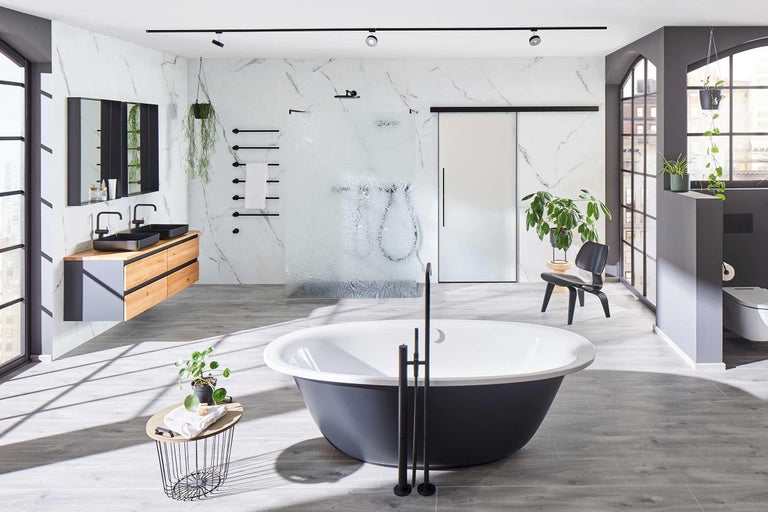 Helles Badezimmer mit freistehender Badewanne, Waschtisch mit zwei Becken, begehbarer Dusche und Marmorwand