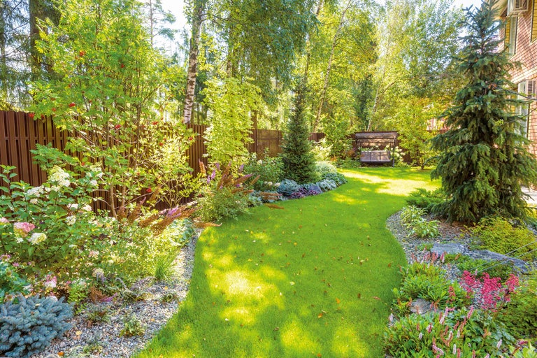 Gartenlandschaft mit Rasenfläche, Blumenbeeten und Ziersträuchern