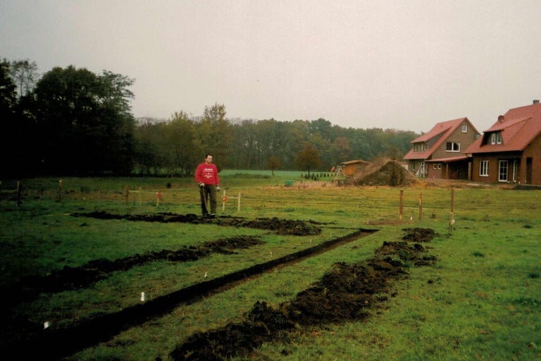 Bauvorbereitung mit ausgehobenen Gräben auf einer Wiese