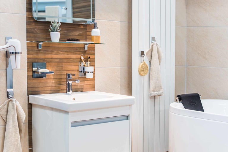 Helles Badezimmer mit Waschbecken, Spiegel, Handtuchwärmer und Badewanne.