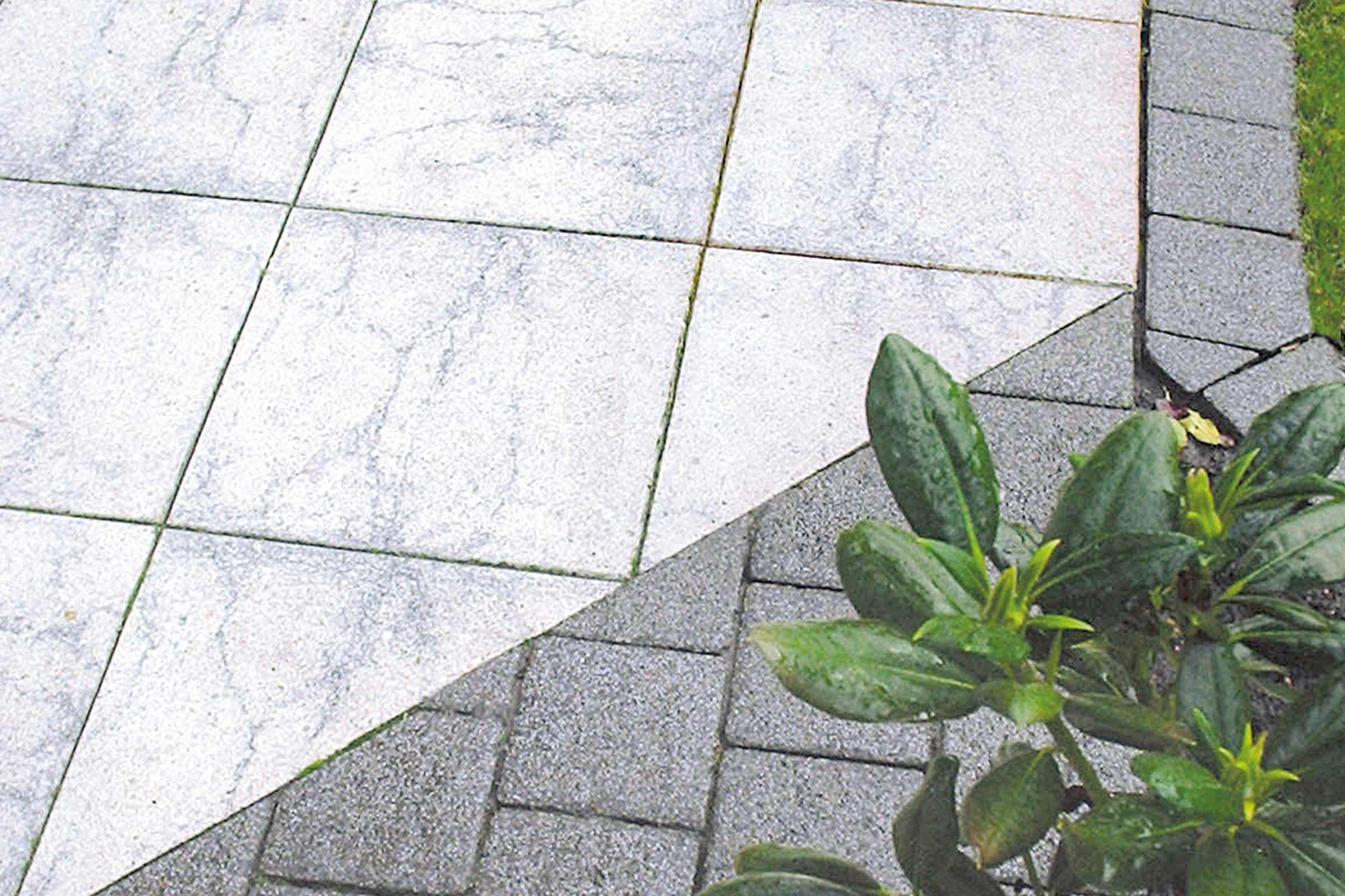 Terrasse mit hellgrauen Betonplatten und dunkelgrauem Pflaster