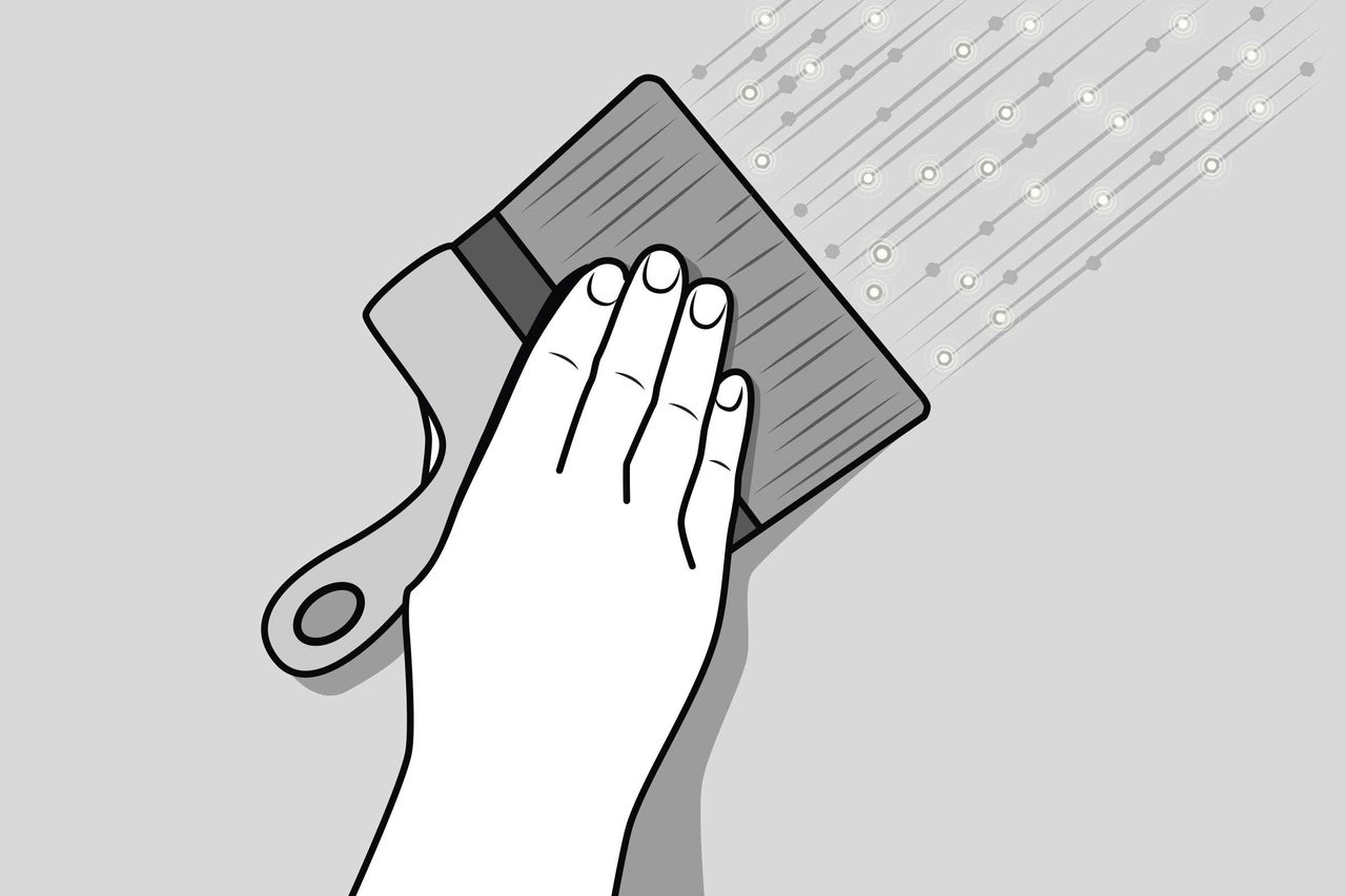 Eine Hand hält eine Bürste beim Auftragen von Farbe auf eine Oberfläche