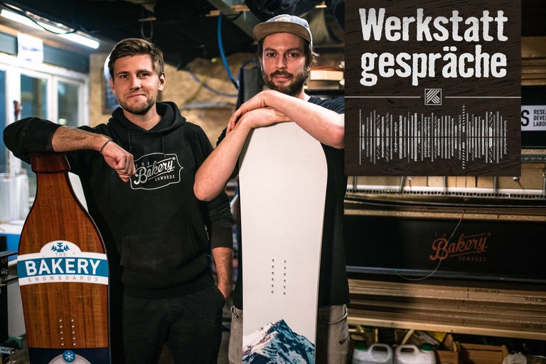 Zwei Personen mit Snowboards der Marke Bakery in einer Werkstatt.