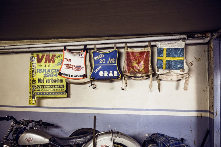 Wand mit Motorradrennsport-Erinnerungsstücken: Poster, Startnummern