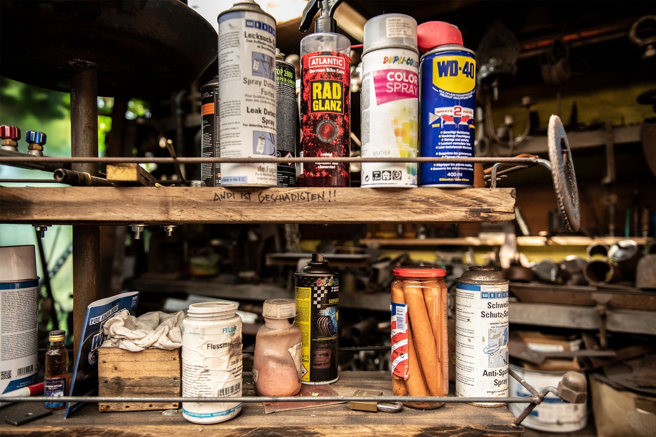 Regal mit verschiedenen Sprays und Werkstattutensilien