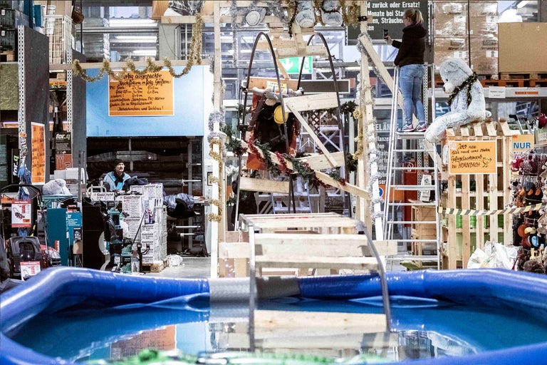 Szene in einem Hornbach Markt mit einem Schwimmbecken, Holzkonstruktionen und ausgestellten Produkten.