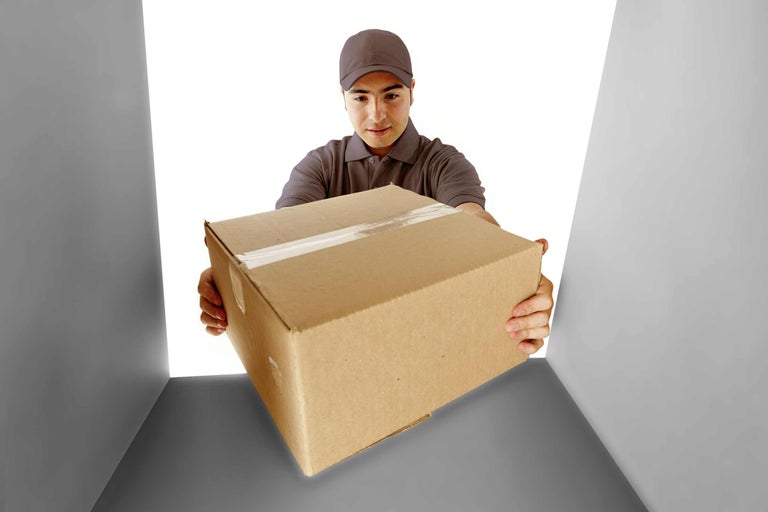 Ein Mann in Arbeitskleidung übergibt ein Paket.