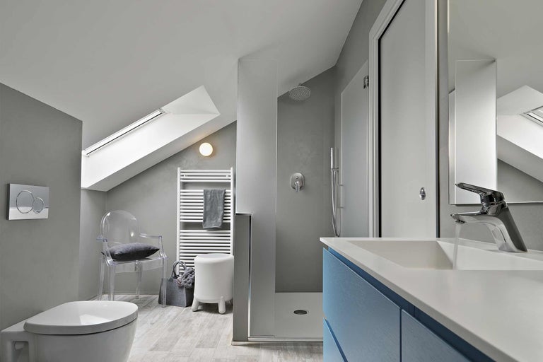 Helles Badezimmer mit Dusche, Waschbecken, Toilette, Heizkörper und Dachfenster