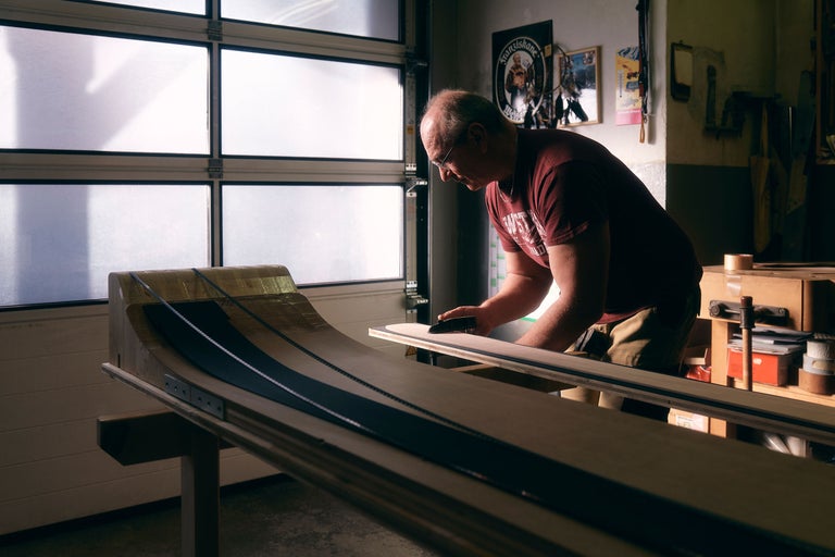 Handwerker bearbeitet Holzkonstruktion in Werkstatt.