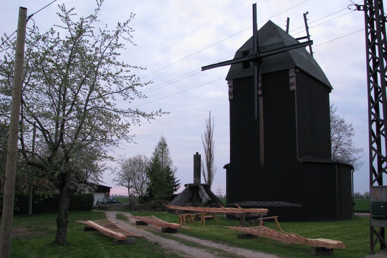 Historische Windmühle mit Holzkonstruktionen auf einem Rasen