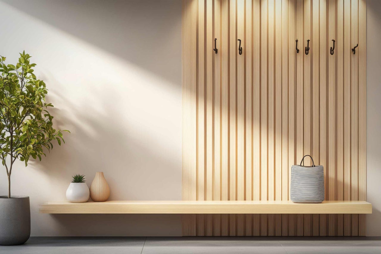 Heller Raum mit Garderobe, Holzbank, Pflanze und Accessoires