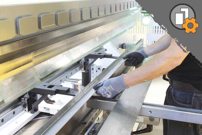 Eine Abkantpresse in Aktion mit einer Person, die ein Metallblech biegt.