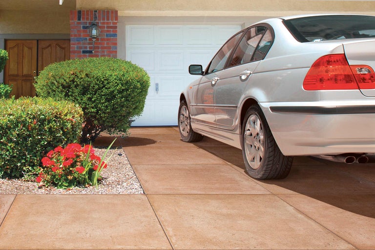 Einfahrt mit Pflastersteinen, Garage und Auto