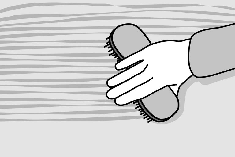 Hand mit Bürste zum Reinigen von Oberflächen