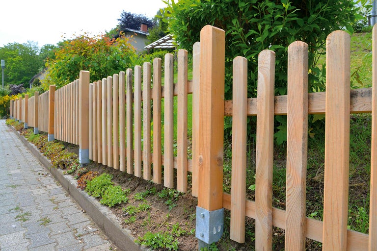 Holzzaun entlang eines Weges im Garten.