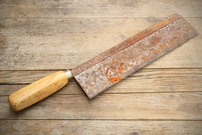 Handsäge mit Holzgriff auf Holztisch