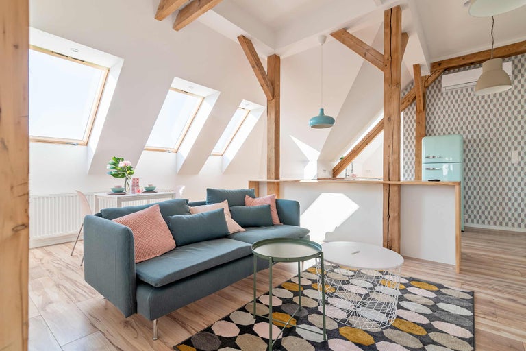 Helles Wohnzimmer mit Sofa, Teppich und Holzelementen