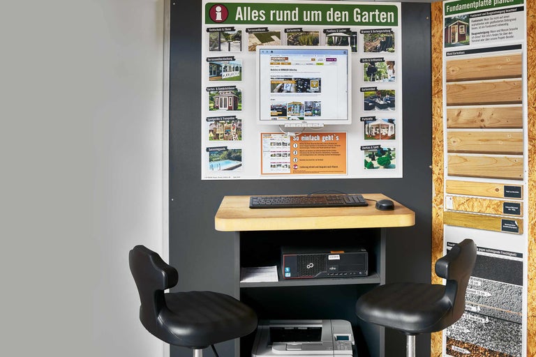 Informationsstand im Hornbach Markt mit Gartenprodukten, Computer, Tastatur, Maus und zwei Stühlen