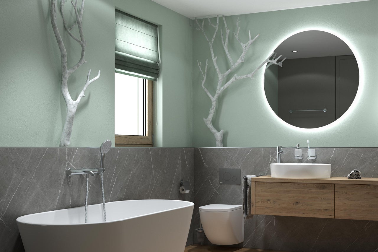 Modernes, helles Badezimmer mit freistehender Badewanne, Wand-WC, Holzwaschtisch, rundem LED-Spiegel, Wänden in Marmoroptik und Ast-Dekoration.
