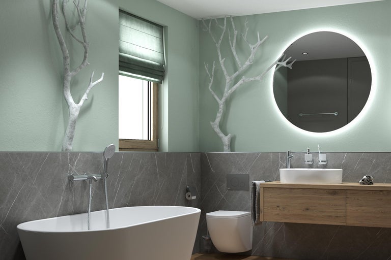 Modernes, helles Badezimmer mit freistehender Badewanne, Wand-WC, Holzwaschtisch, rundem LED-Spiegel, Wänden in Marmoroptik und Ast-Dekoration.