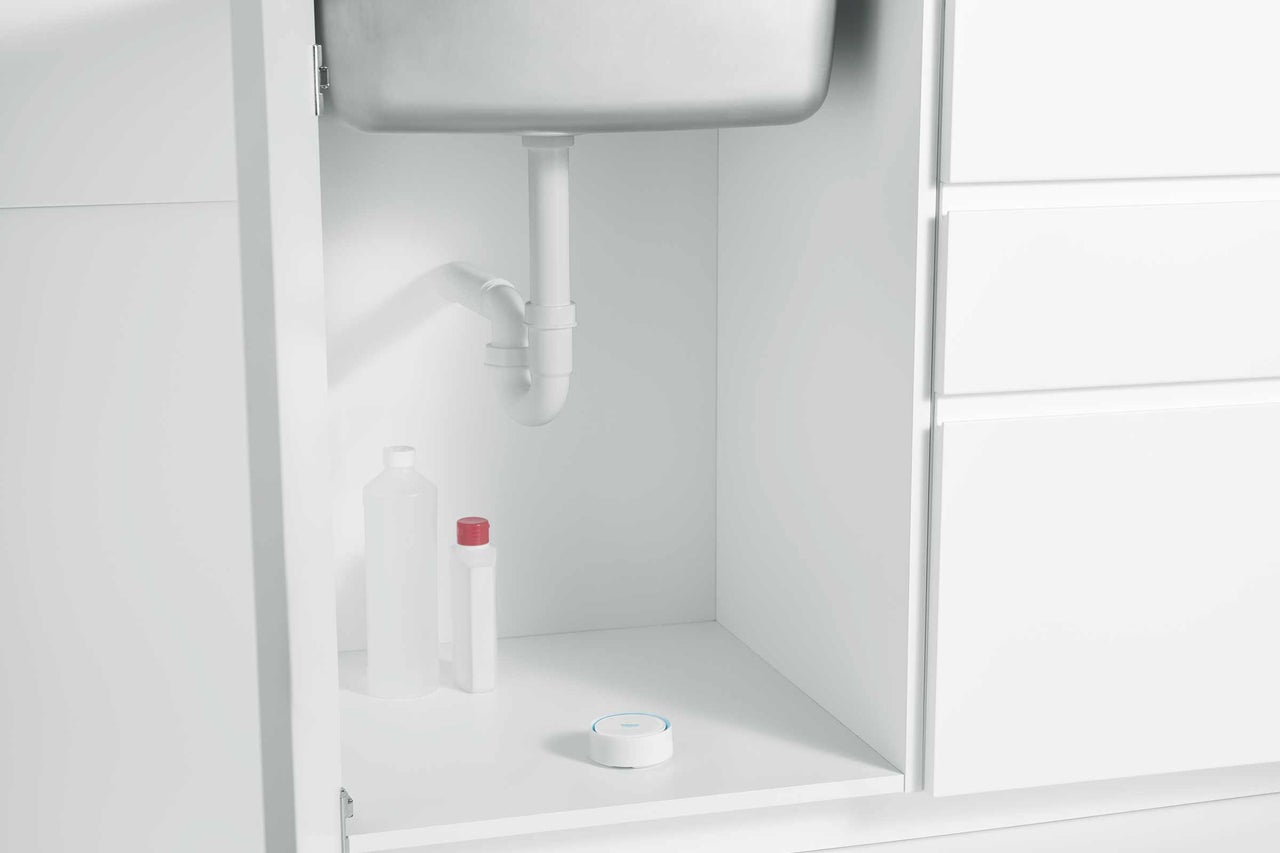 Blick unter das Spülbecken mit Siphon, Reinigungsflaschen und Dichtring