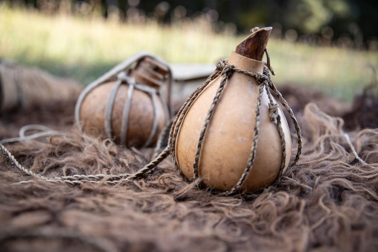 Zwei Feldflaschen aus Kürbis mit Schnur auf einem Fell