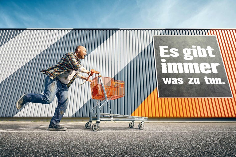 Mann rennt mit Einkaufswagen vor Hornbach Werbeplakat