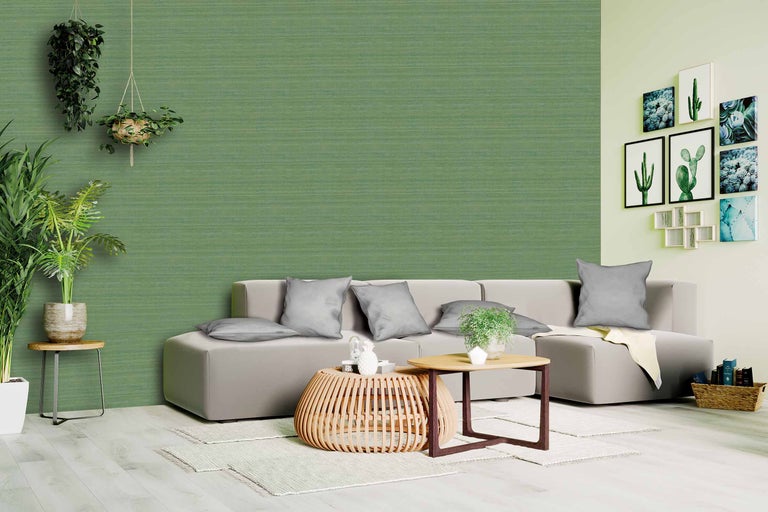 Wohnzimmer mit grüner Wandtapete, Sofa und Couchtischen