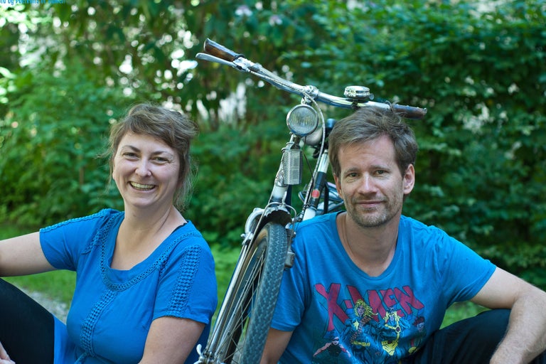 Frau und Mann sitzen vor einem Fahrrad