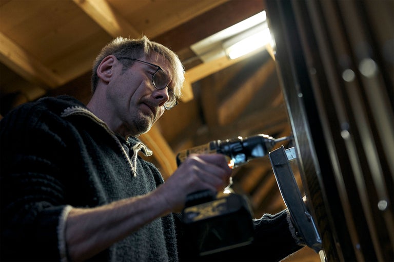 Handwerker arbeitet mit einem Akkuschrauber an einem Metallrahmen