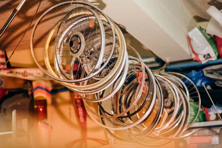 Mehrere Fahrradfelgen hängen an der Decke eines Raumes.