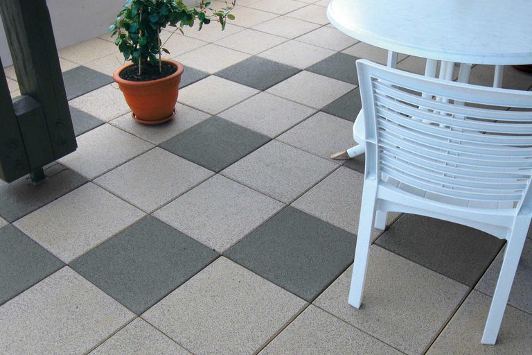 Terrasse mit Terrassenplatten in Schachbrettmuster, Tisch, Stuhl und Topfpflanze