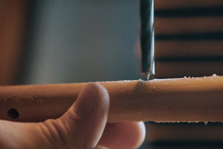 Ein Bohrer bohrt ein Loch in ein Holzstück.