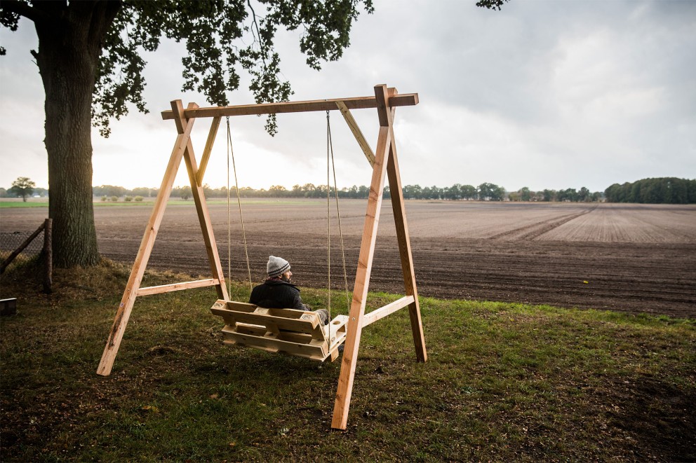 Autor Sascha Borrée schaukelt auf seiner selbst gebauten Hollywoodschaukel mit Blick auf ein Feld. Autor Sascha Borrée schaukelt auf seiner selbst gebauten Hollywoodschaukel mit Blick auf ein Feld.