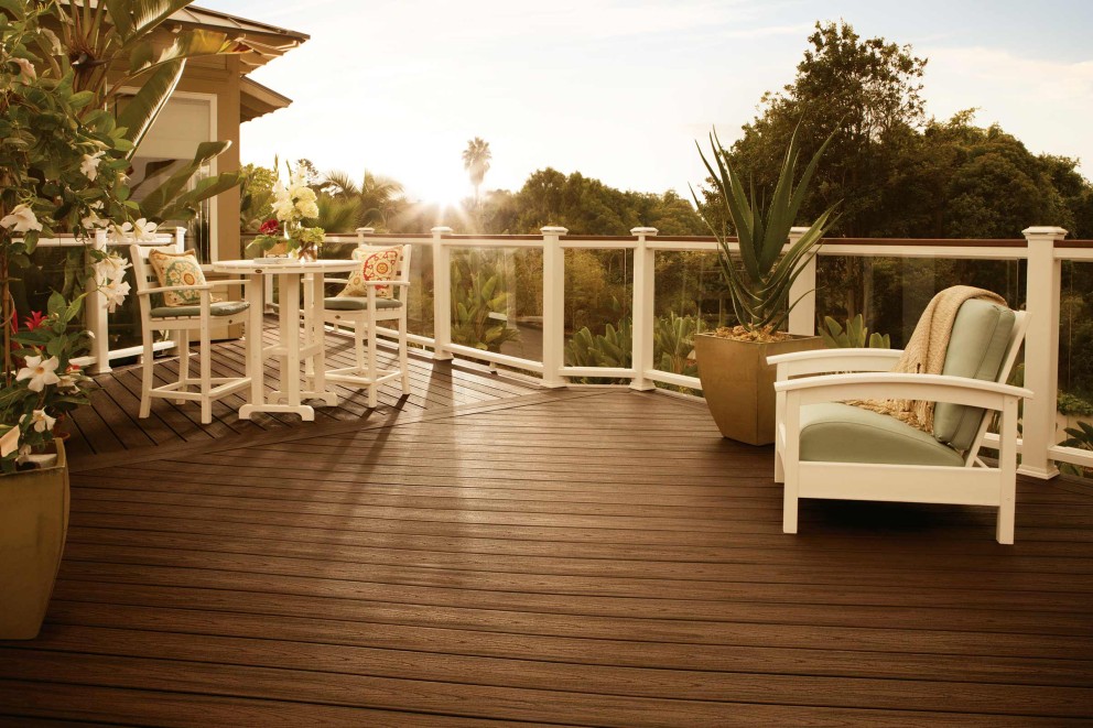 Terrasse mit Terrassendielen, Geländer, Gartentisch und Gartenstühlen