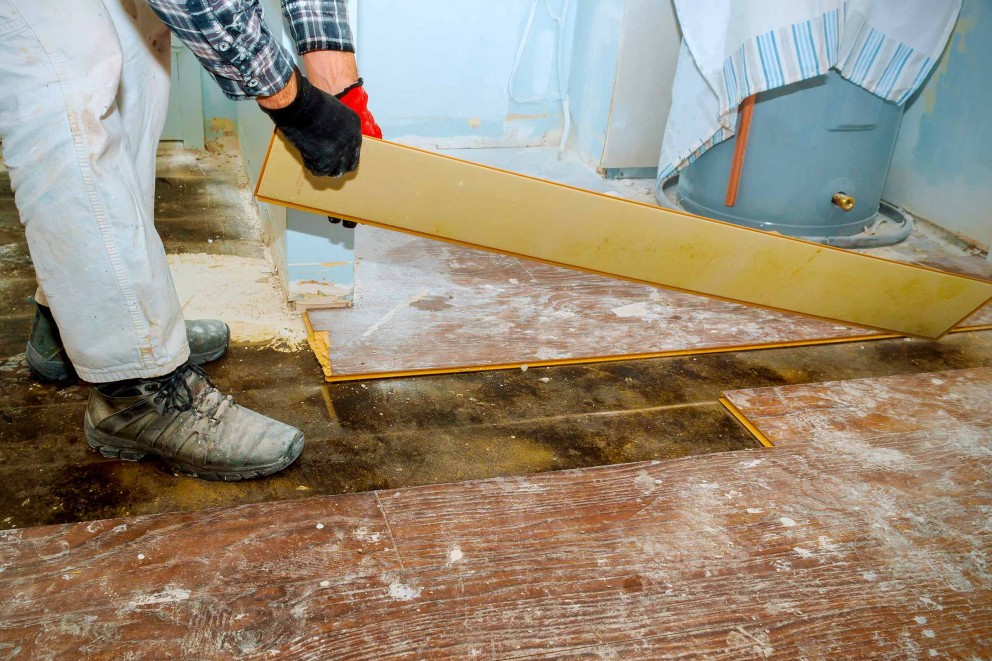 Handwerker verlegt Laminatboden in einem Raum.