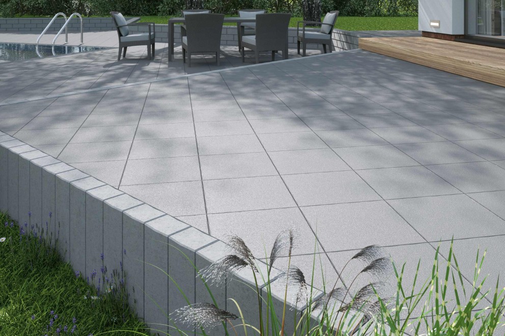 Terrasse mit grauen Terrassenplatten, Gartenmöbeln und Pool