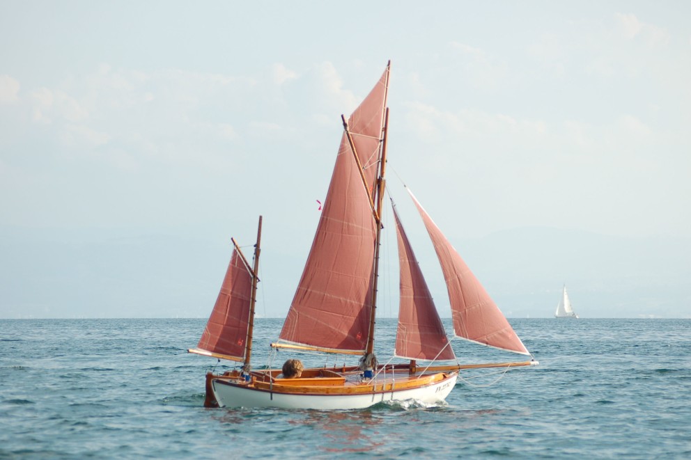 Mini Dingi mit rotbraunen Segeln. Mini Dingi mit rotbraunen Segeln.