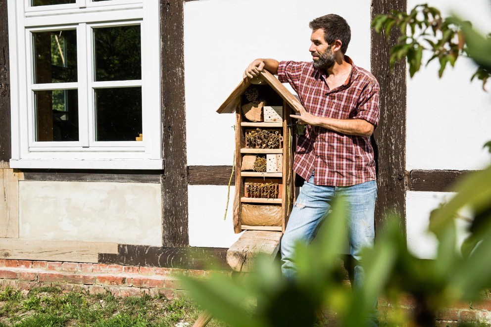 Autor Sascha Borrée steht neben seinem selbst gebauten Insektenhotel und wartet auf erste Bewohner. Autor Sascha Borrée steht neben seinem selbst gebauten Insektenhotel und wartet auf erste Bewohner.