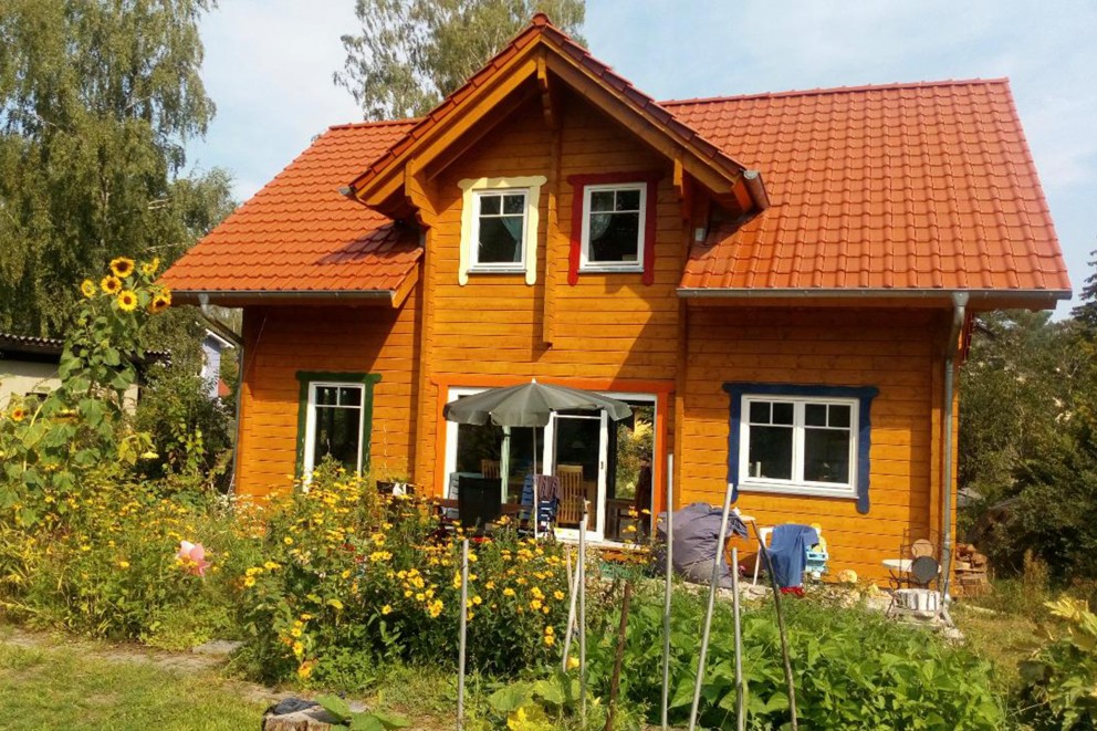 Holzhaus mit Ziegeldach und Garten