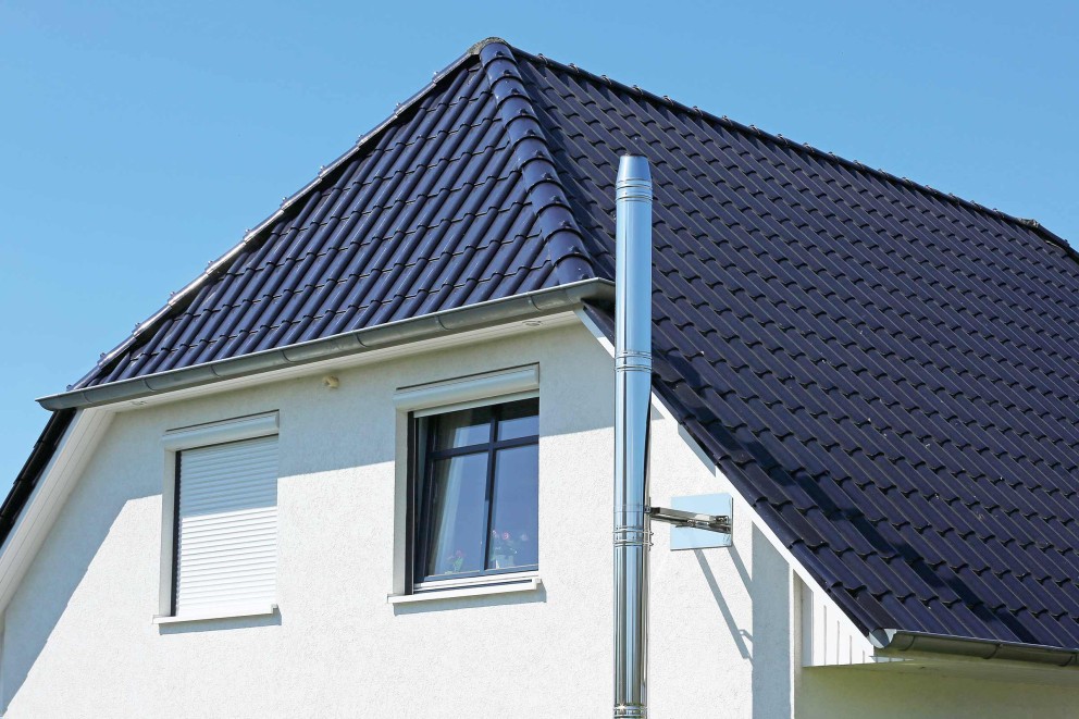 Außenansicht eines Hauses mit Schornstein und Dachziegeln