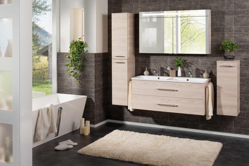 Modernes Badezimmer mit Waschtisch, Spiegelschrank, Hochschrank, Badewanne und Teppich