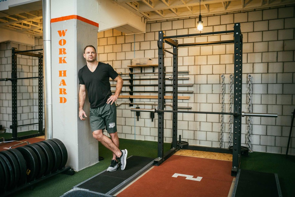 Fitnessstudio mit Gewichtheberaum und Mann an einer Wand