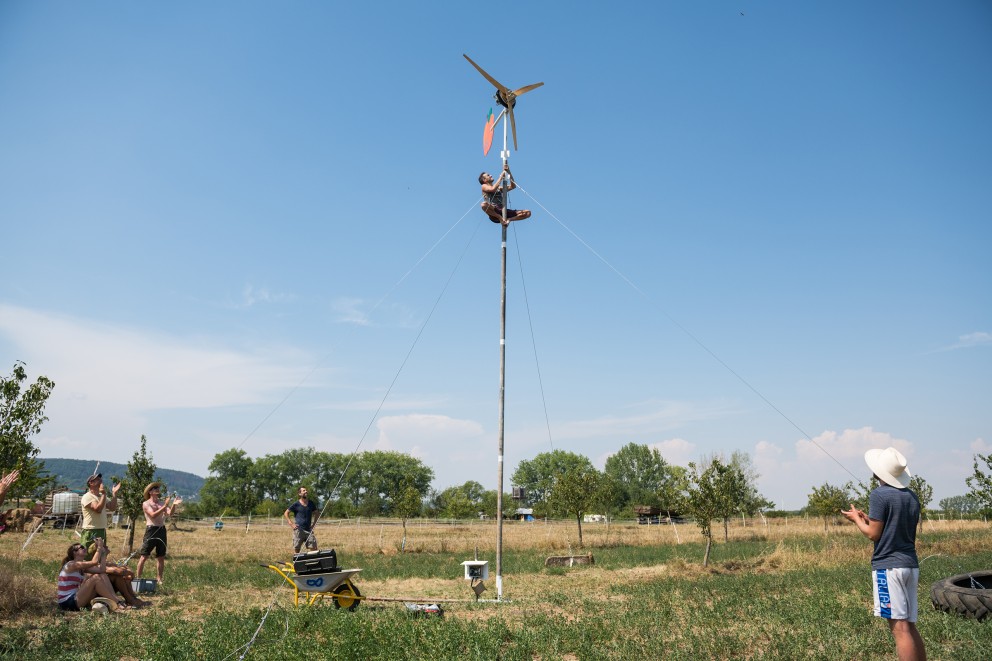 Nachdem Workshop Leiter Jonathan Schreiber schnurstracks den Mast raufgeklettert ist und dem Rotor einen Schubs gegeben hat, ist das selbst gebaute Windrad endlich in Betrieb. Nachdem Workshop Leiter Jonathan Schreiber schnurstracks den Mast raufgeklettert ist und dem Rotor einen Schubs gegeben hat, ist das selbst gebaute Windrad endlich in Betrieb.