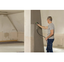 Mann streicht Wand mit Farbspritzgerät