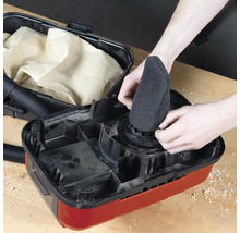 Ein Mann setzt einen Filter in einen Staubsauger.